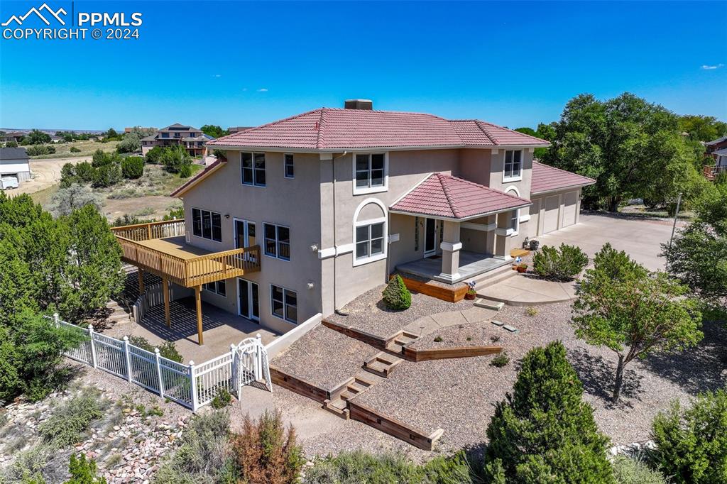 front and west side of property with a wooden deck and a patio area