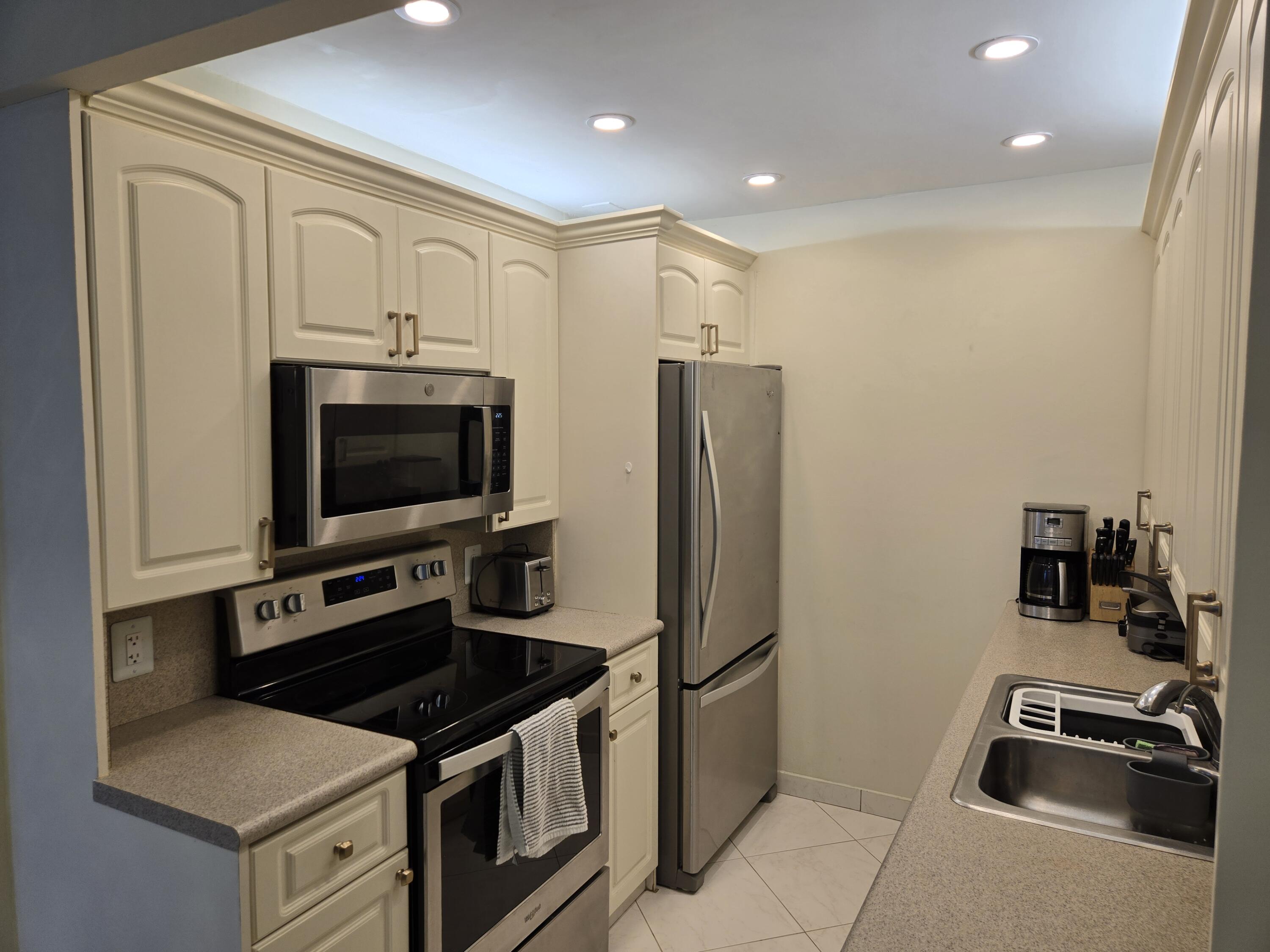 a kitchen with stainless steel appliances a refrigerator a stove a microwave and a sink