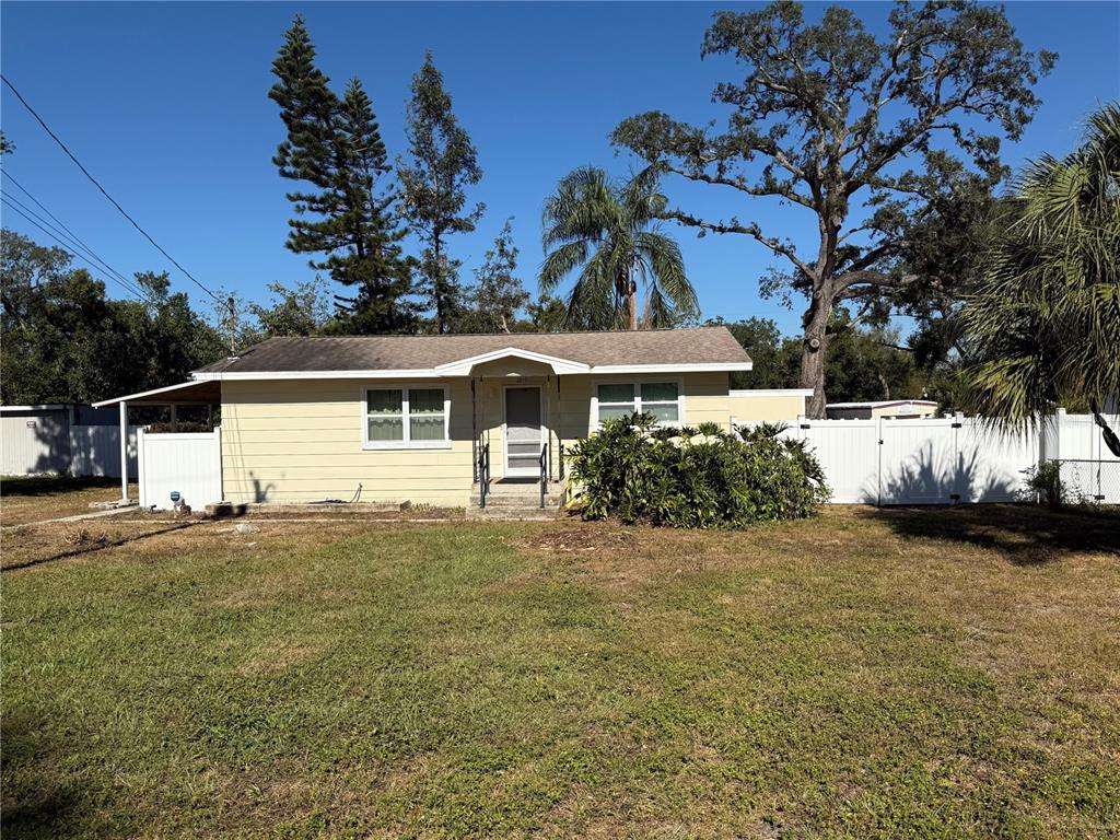 a front view of a house with a garden and tree