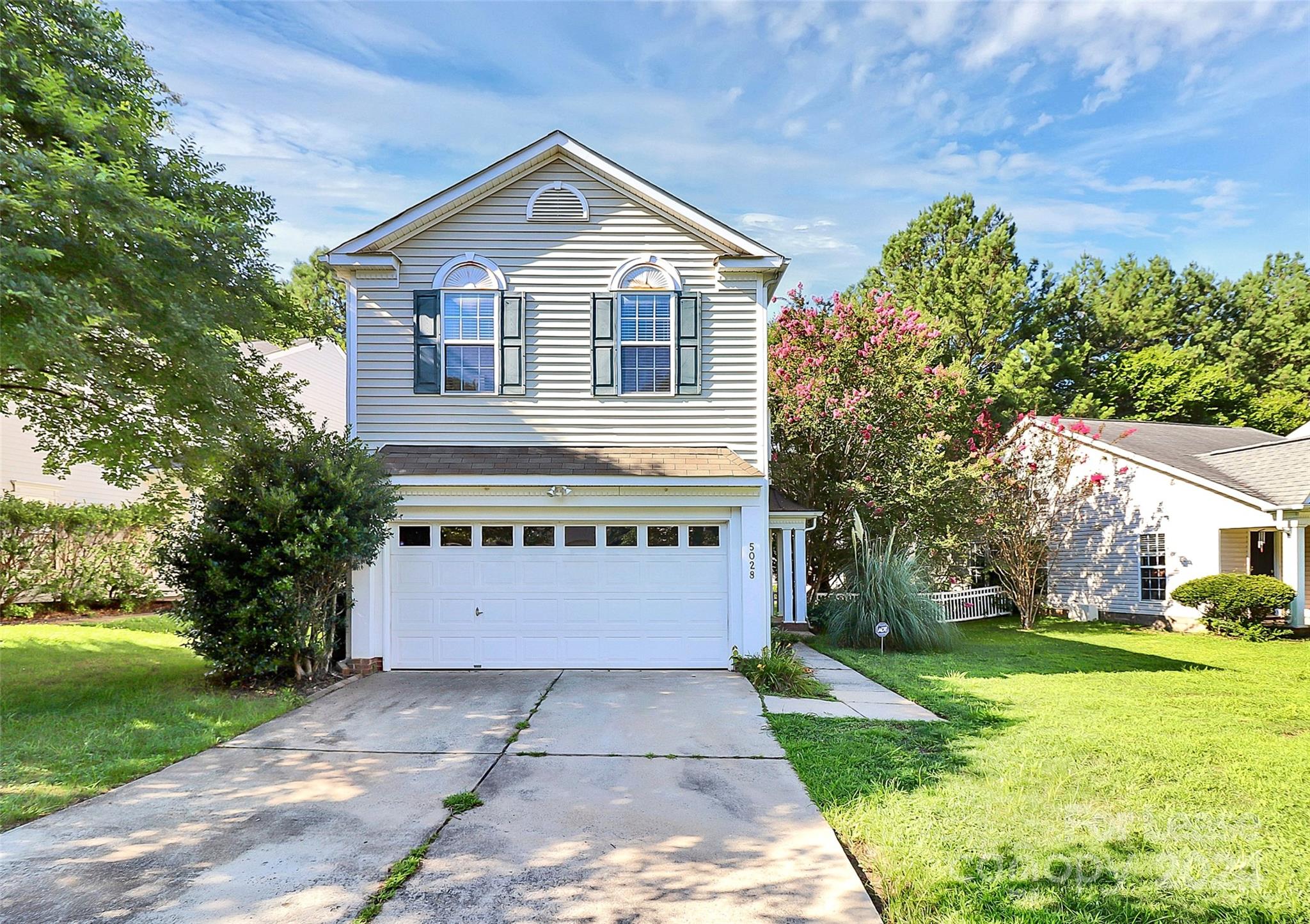 a front view of a house with a yard and trees