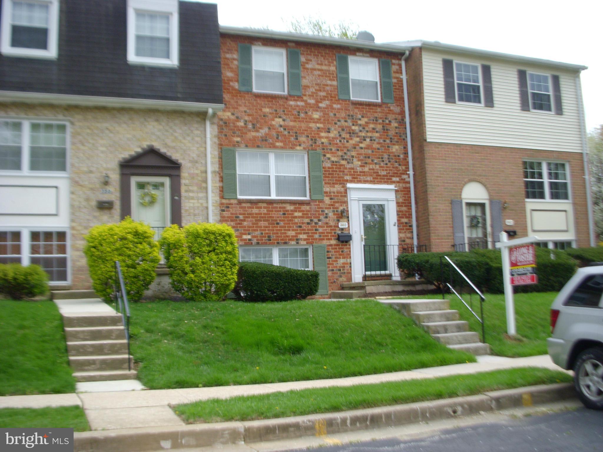 a view of a brick house with a yard garden and plants