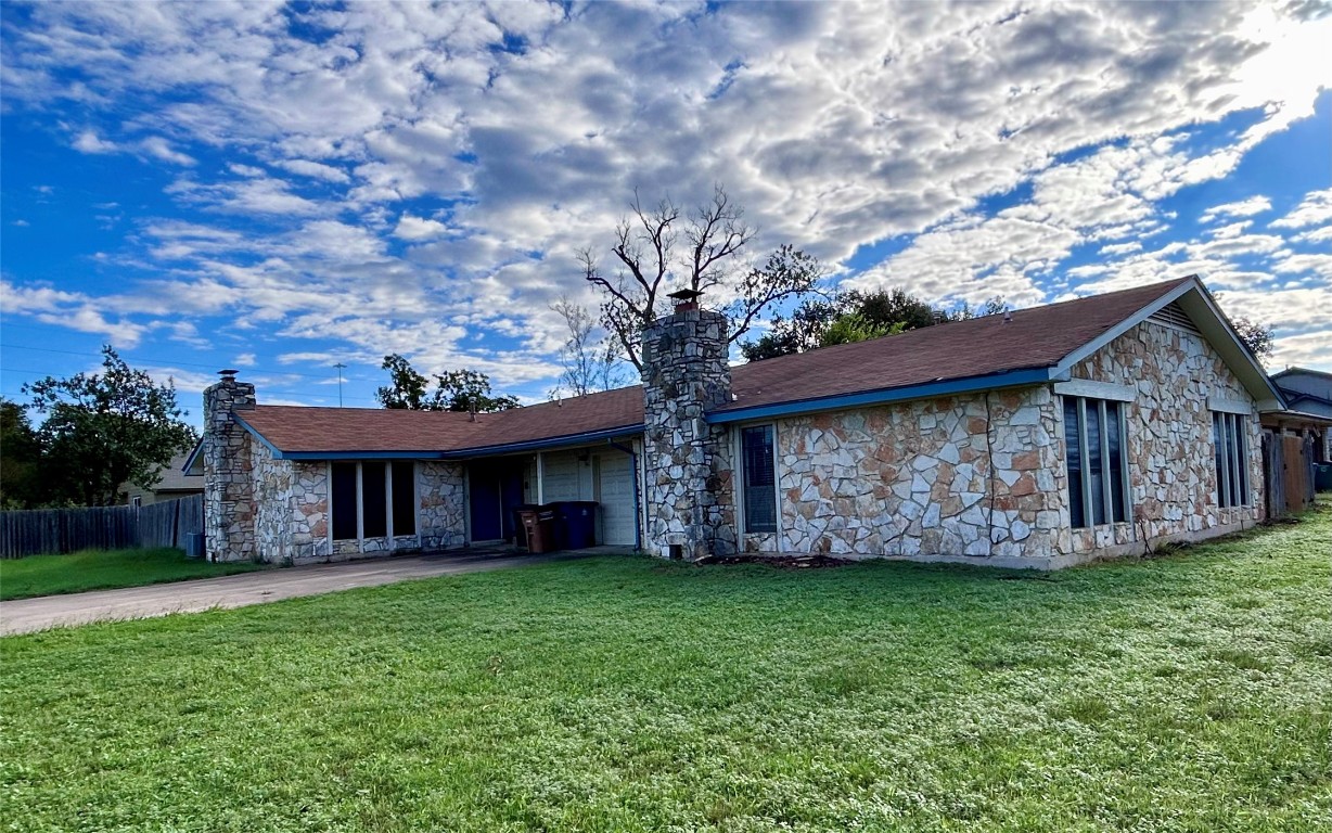 a view of a house with a yard potted plants and large tree