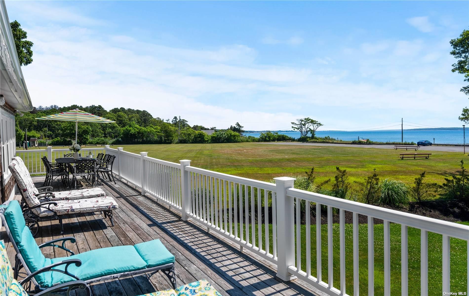 a view of a balcony with wooden floor & fence