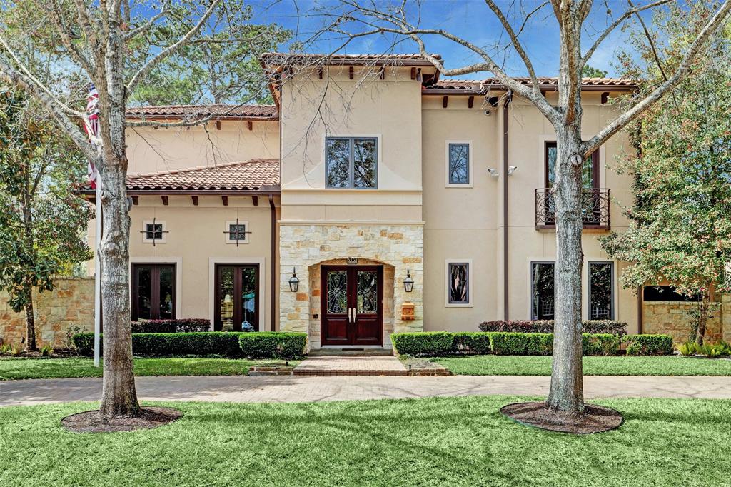 a view of a white house with a small yard and large tree