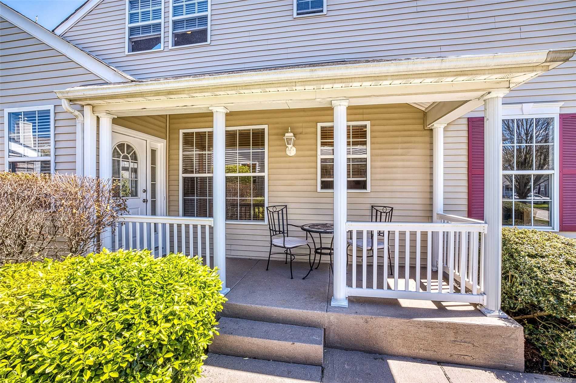 a front view of a house with a chairs and table