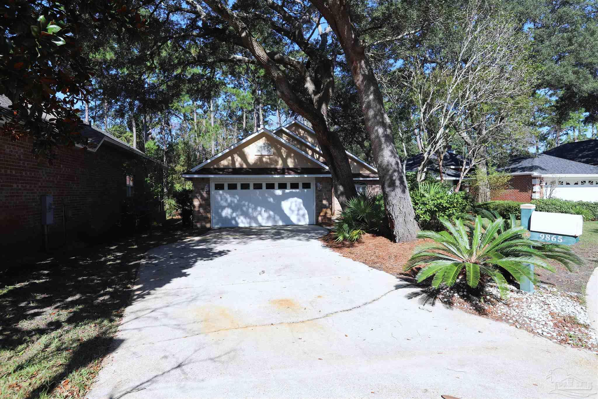 a front view of a house with a yard and a garden