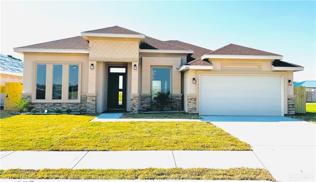 Prairie-style home featuring a front yard and a garage