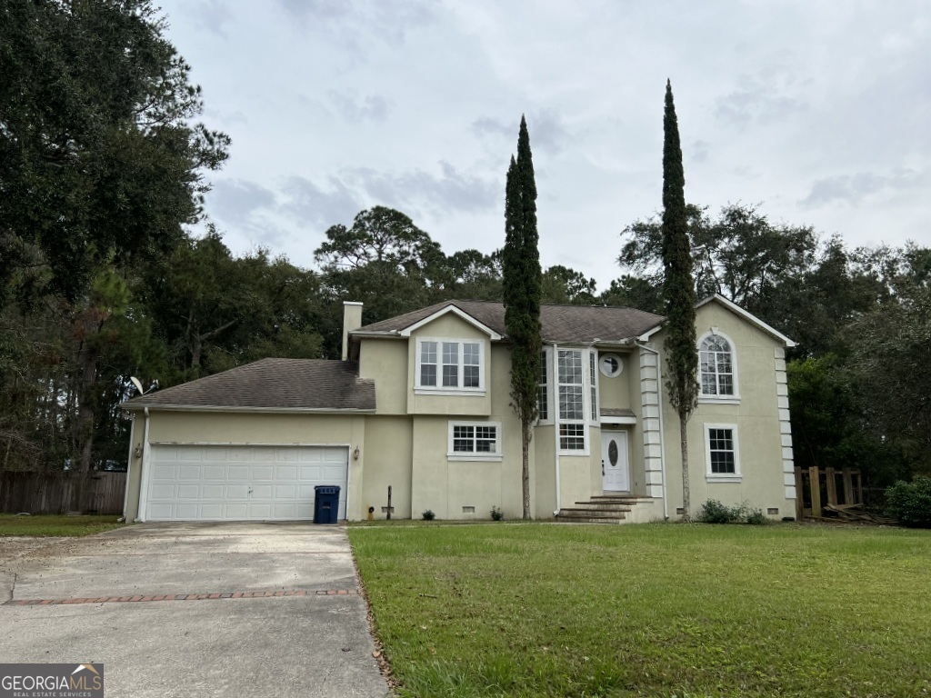 a front view of a house with a garden and yard