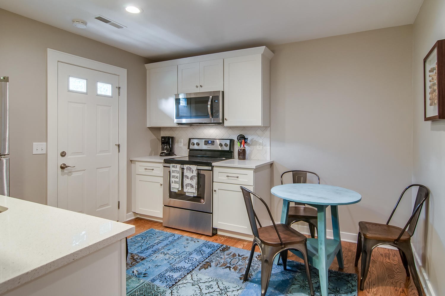 a kitchen with stainless steel appliances kitchen island granite countertop a sink a stove a table and chairs