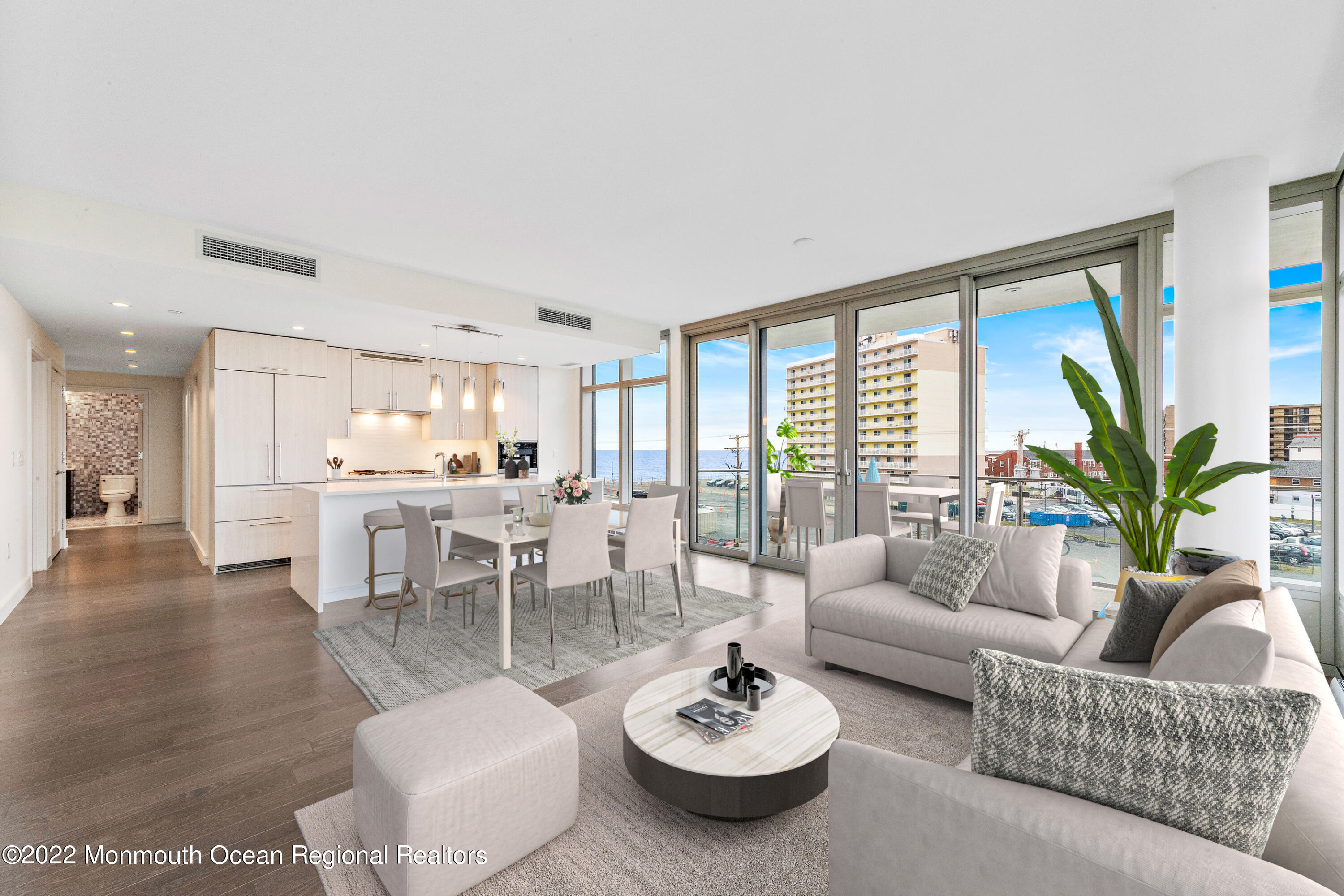 a living room with furniture kitchen view and a large window