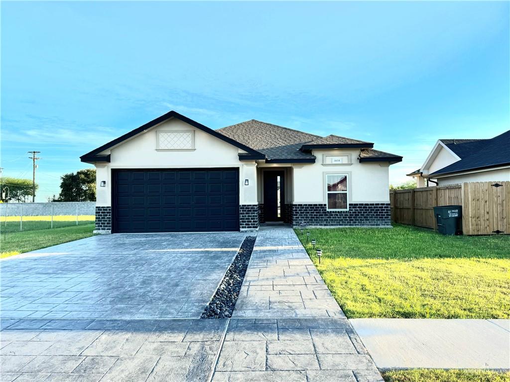 View of front facade with a garage and a front lawn