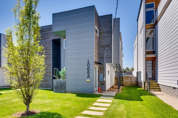 a view of an house with backyard space and a tree