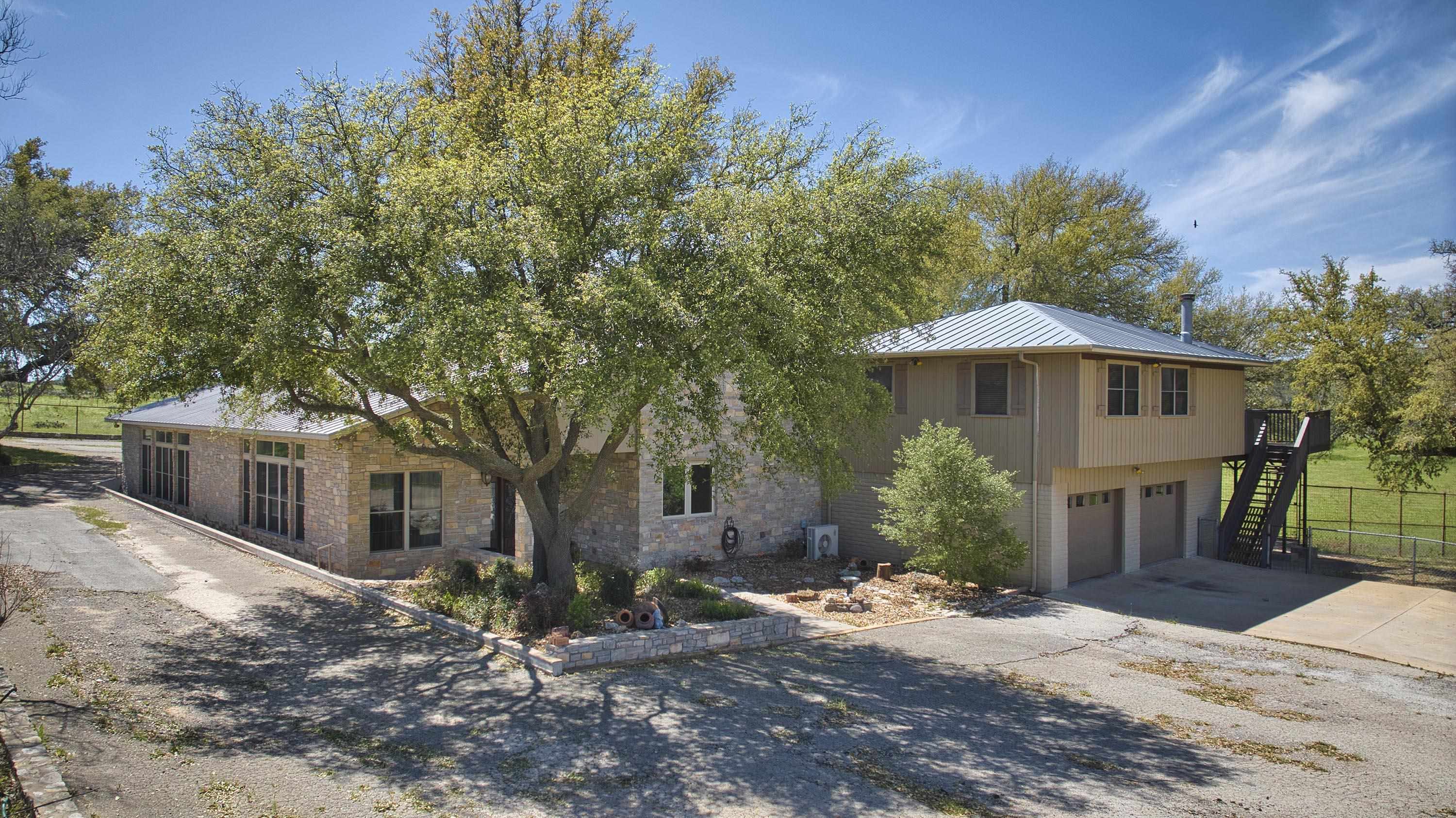 a front view of a house with yard and tree