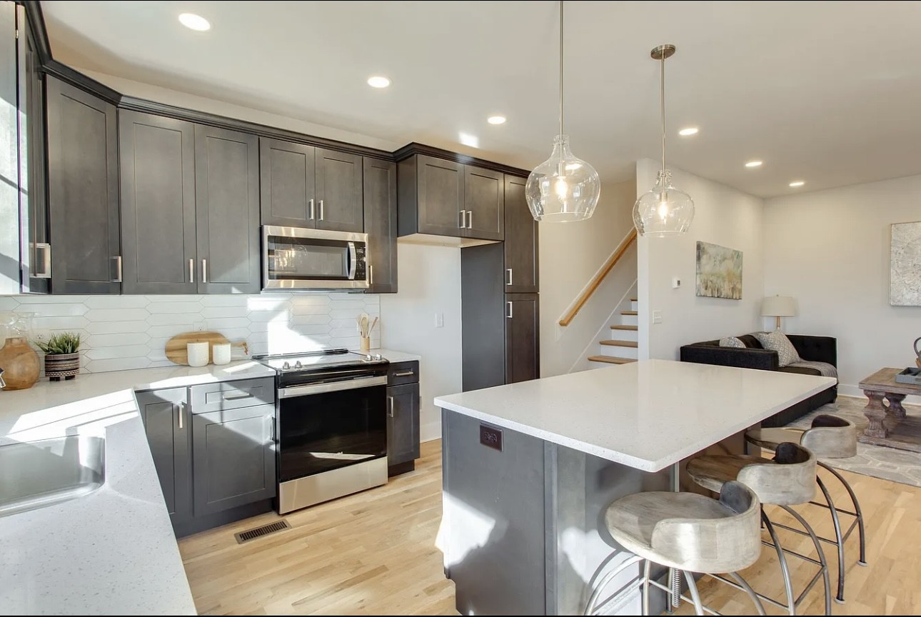 a kitchen with a table chairs microwave and cabinets