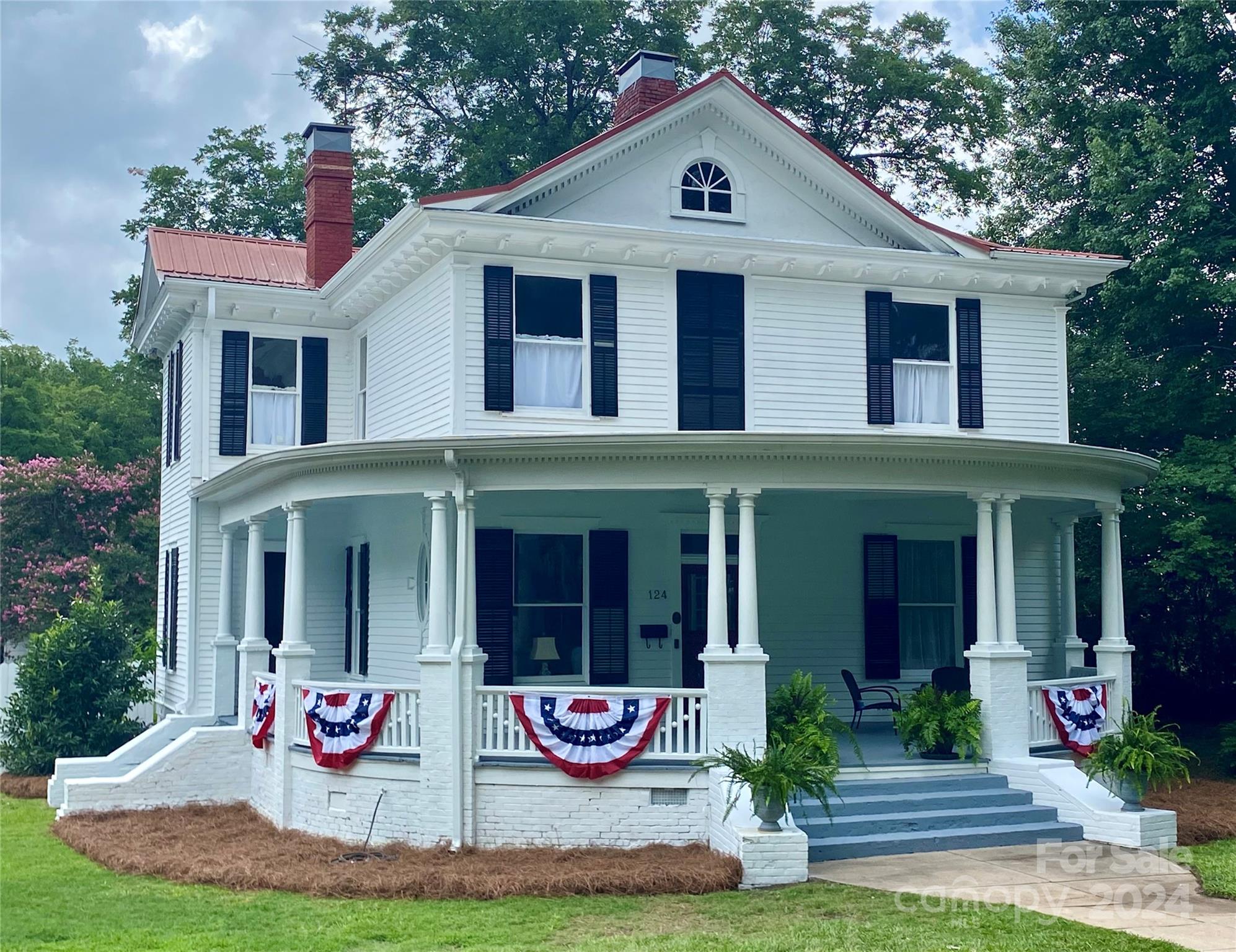 a front view of white house with yard