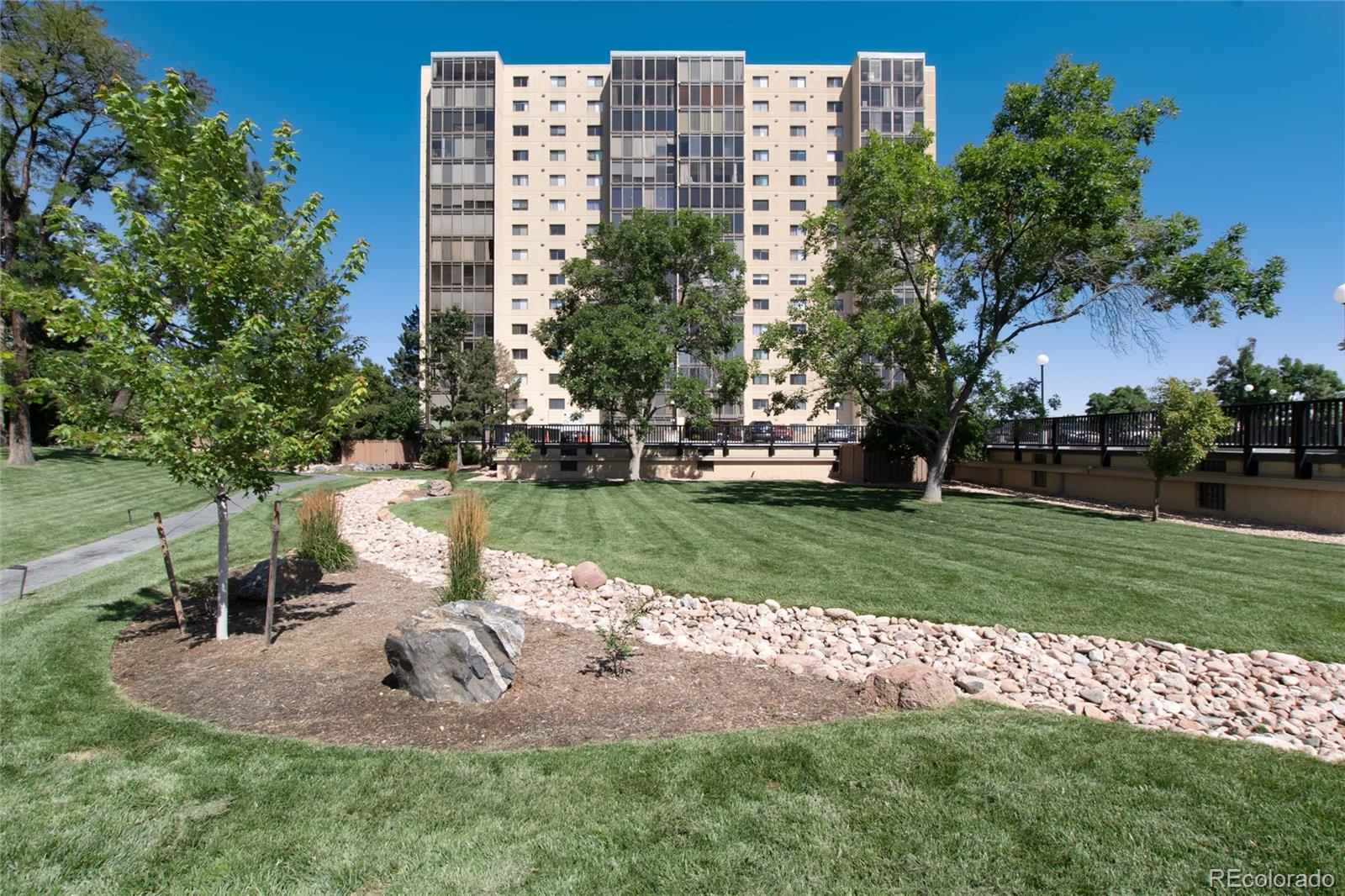 a view of a park with a fountain and a tree