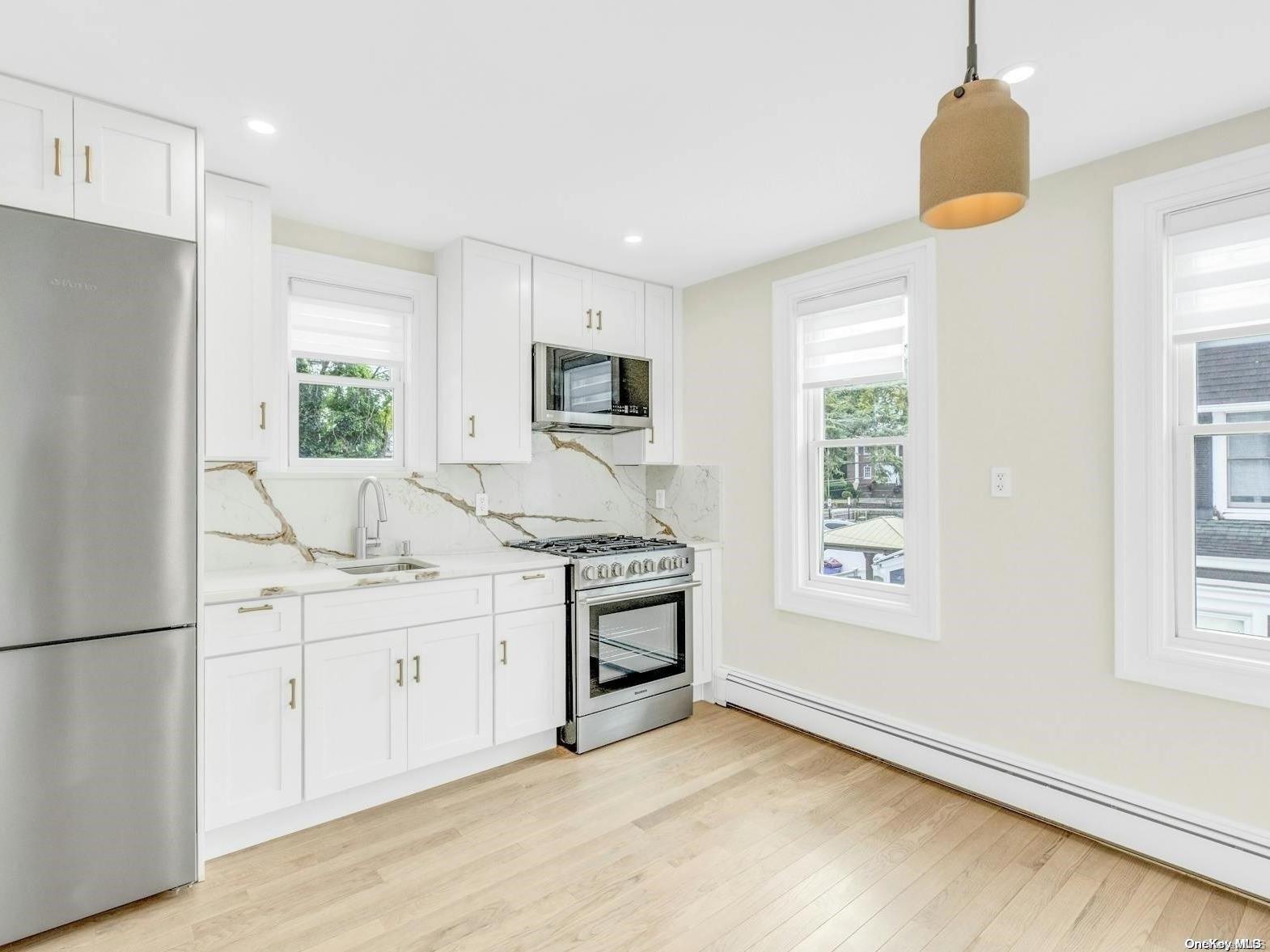 a kitchen with white cabinets and a refrigerator