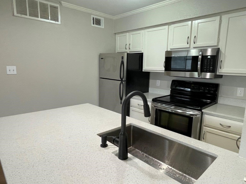 a kitchen with stainless steel appliances a refrigerator and a stove top oven