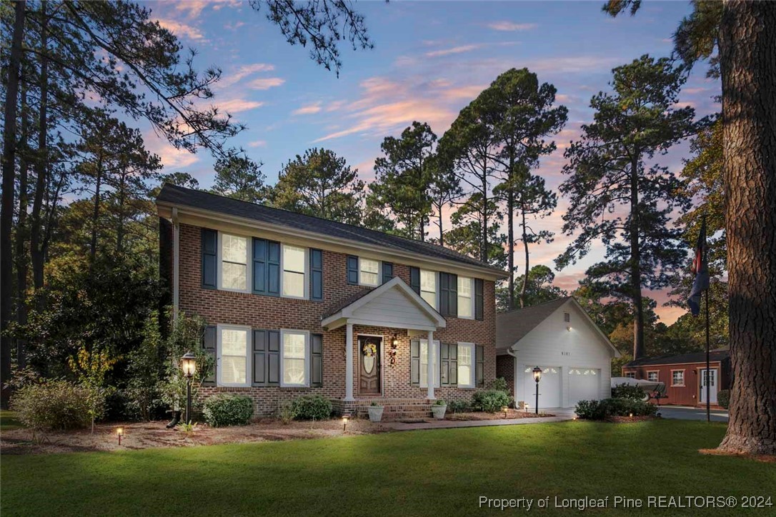 a front view of a house with a garden and trees