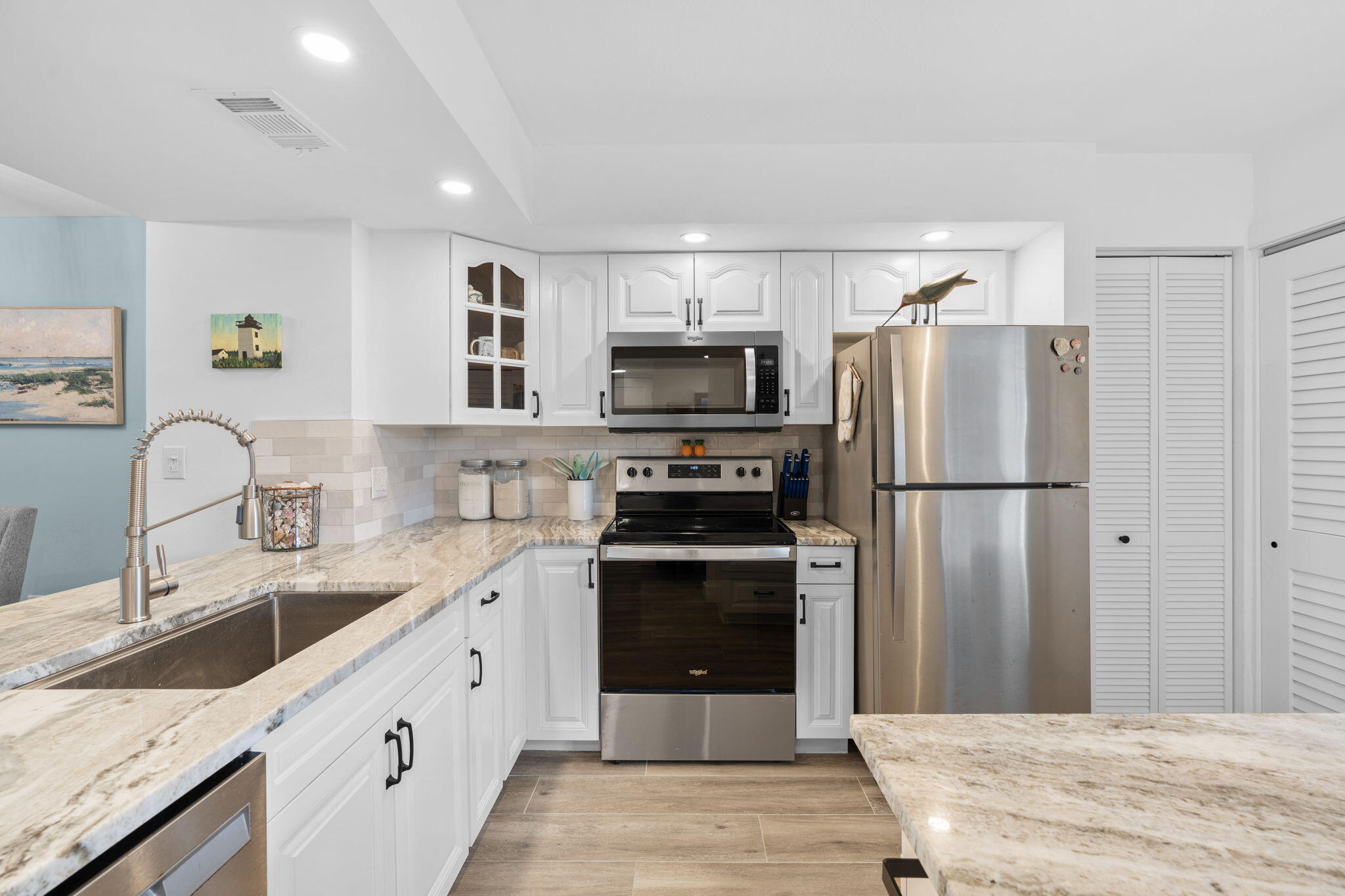 a kitchen with stainless steel appliances granite countertop a refrigerator and a sink