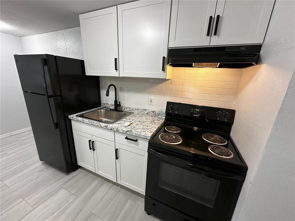 a kitchen with stainless steel appliances granite countertop a stove and a refrigerator