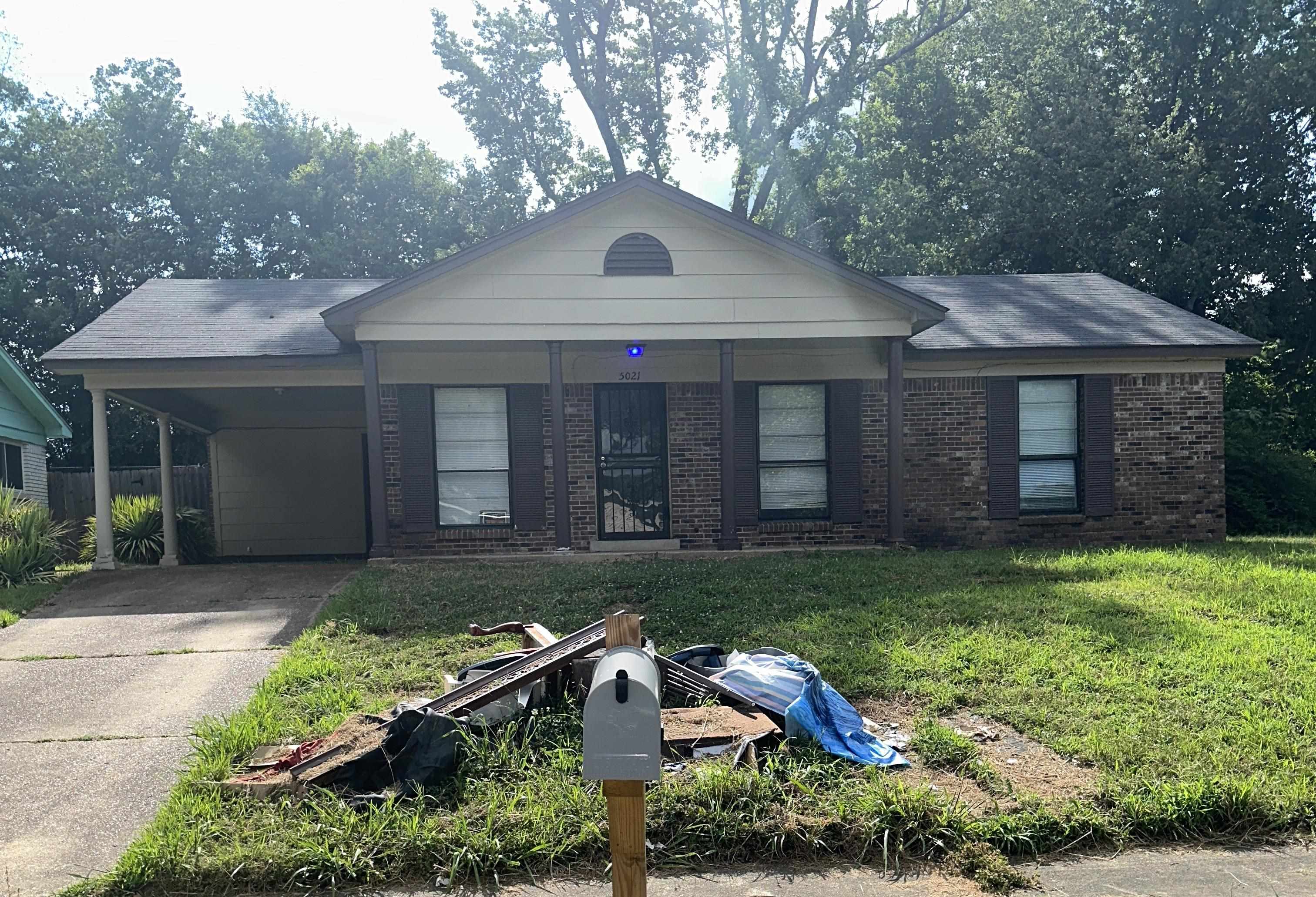 Ranch-style house with a front lawn and a carport