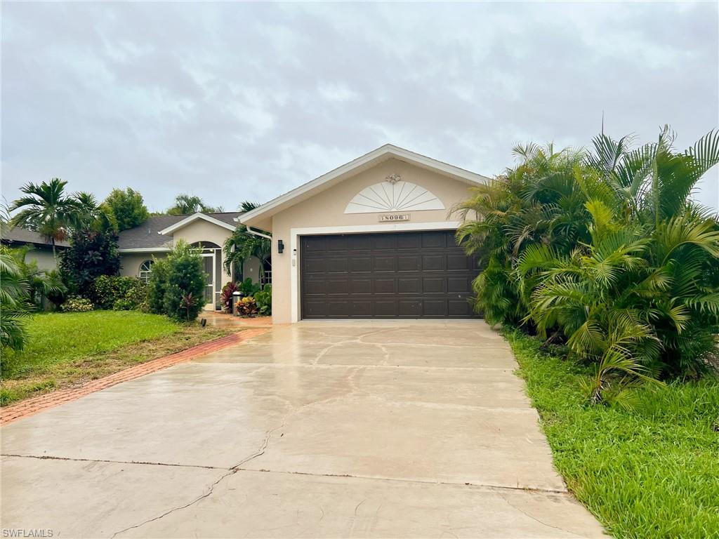 a front view of a house with a yard and trees