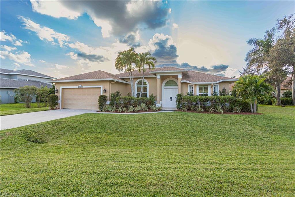 Ranch-style house featuring a garage and a front lawn