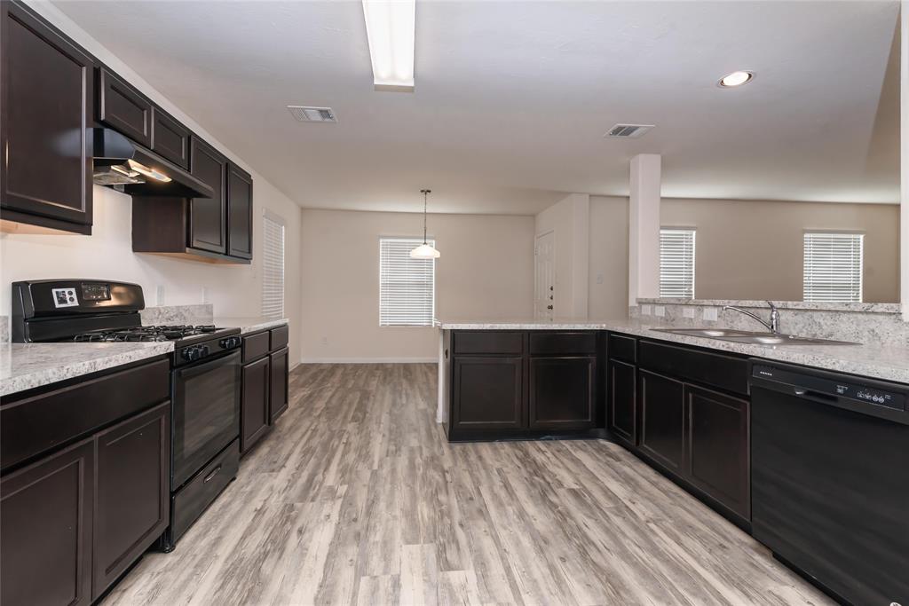 a kitchen with stainless steel appliances granite countertop a stove a sink and a microwave