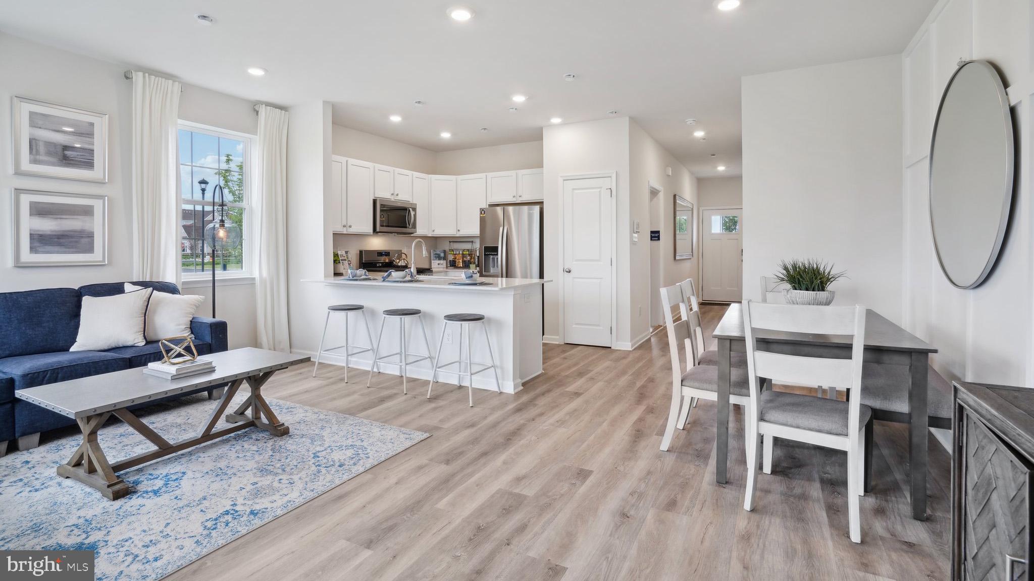 a living room with furniture a dining table and kitchen view