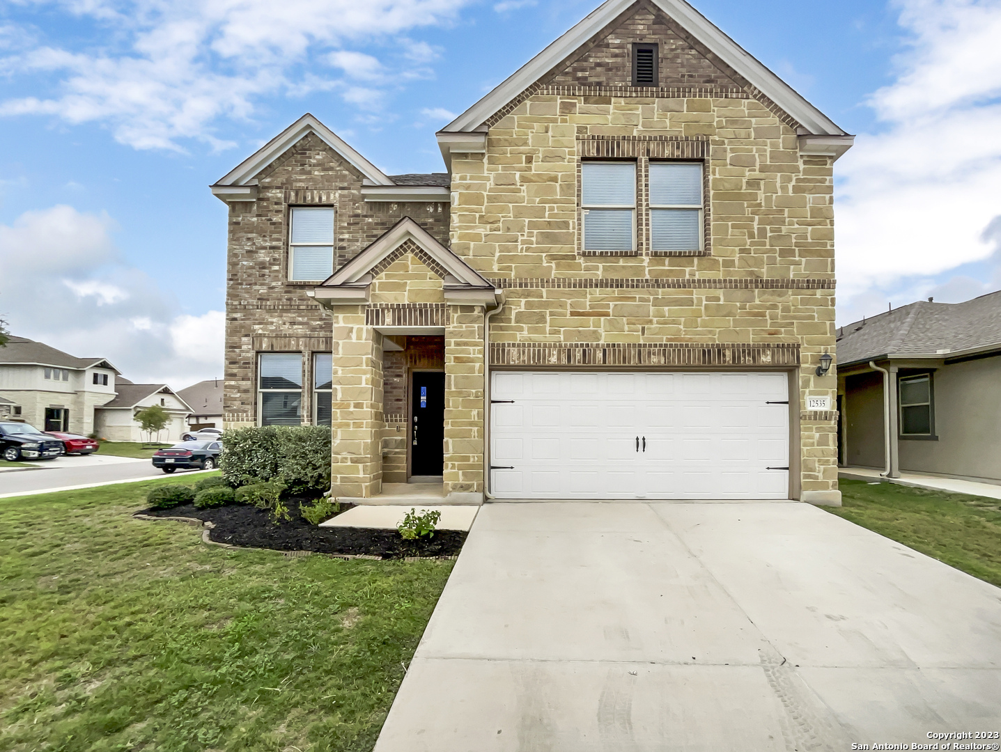 a front view of a house with a yard and garage