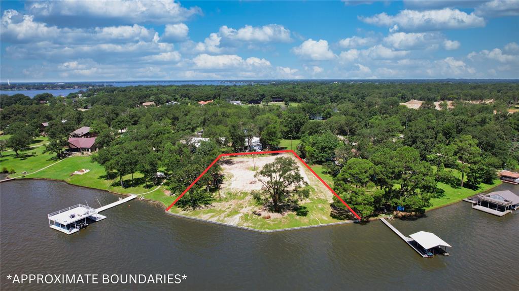 an aerial view of a house with a yard and lake view in back