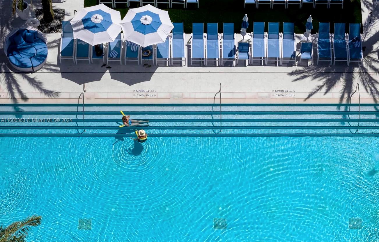 a view of swimming pool with a patio and plants