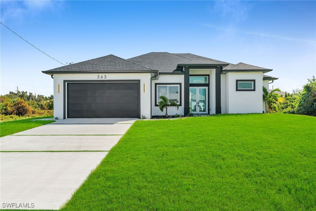 a front view of a house with a yard and garage