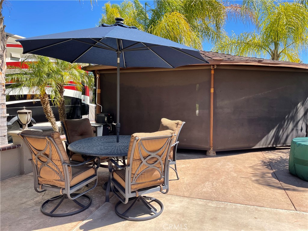 a patio with a table and chairs under an umbrella