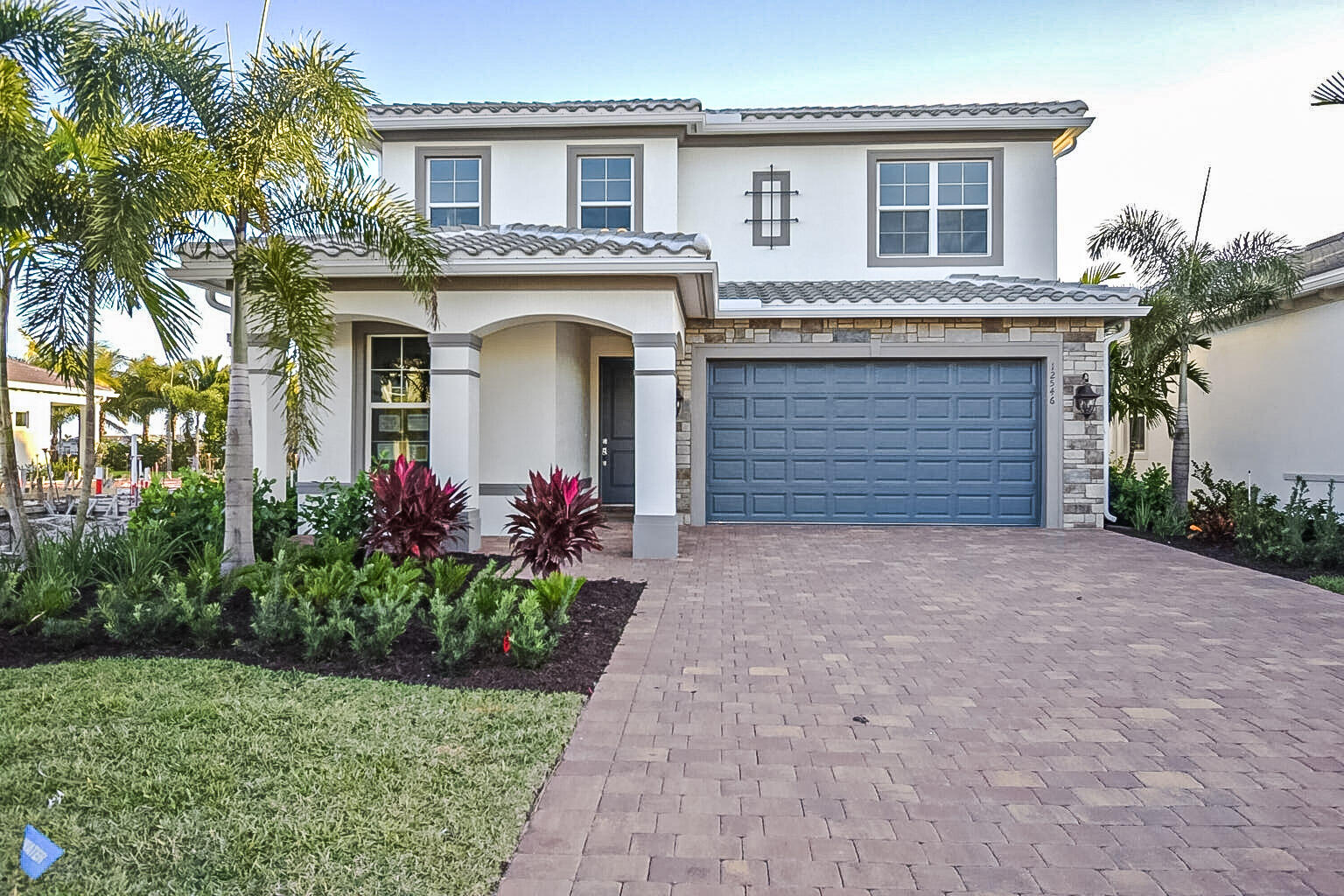 a front view of a house with a garden and garage