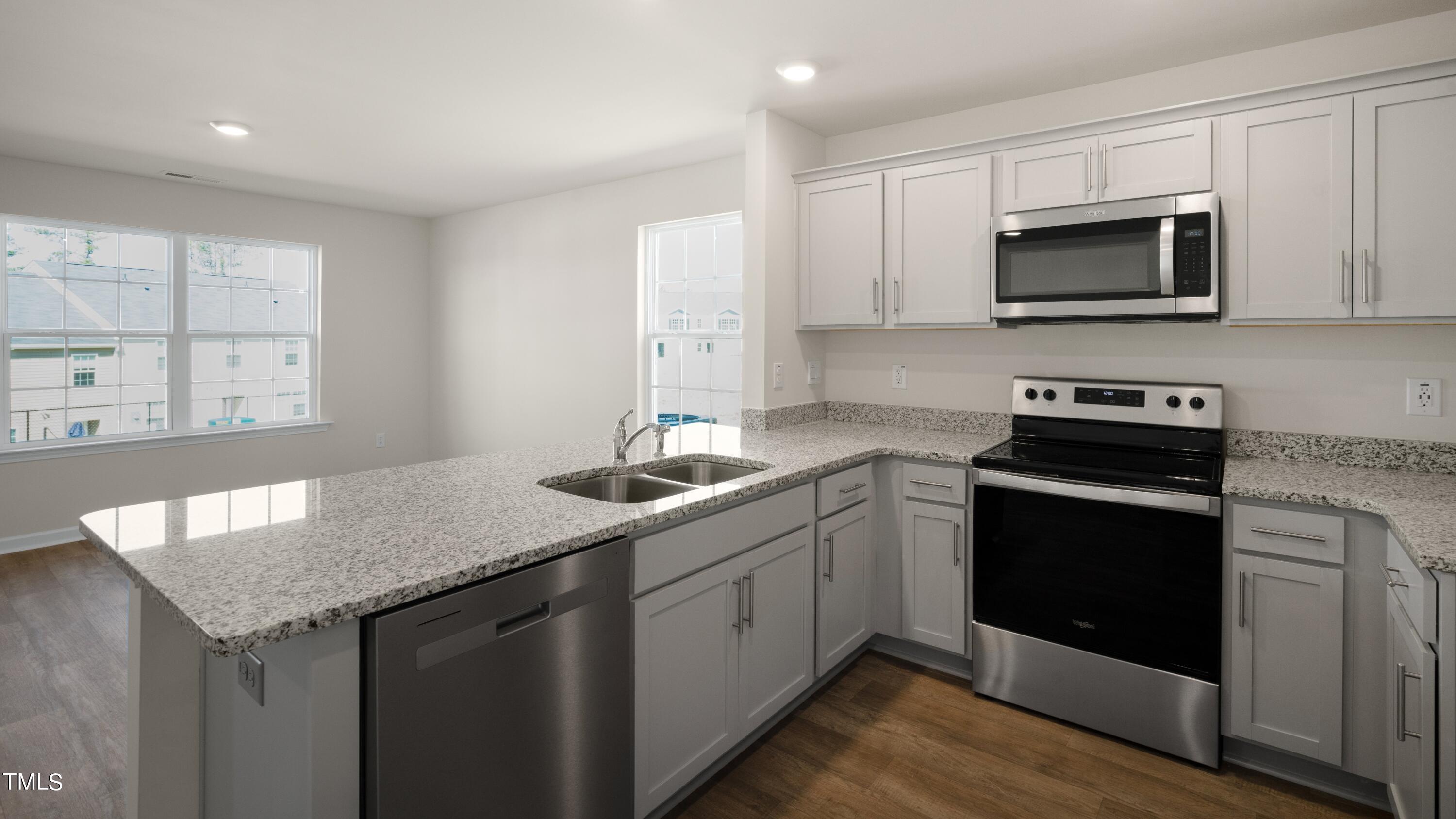 a kitchen with a sink stove and microwave