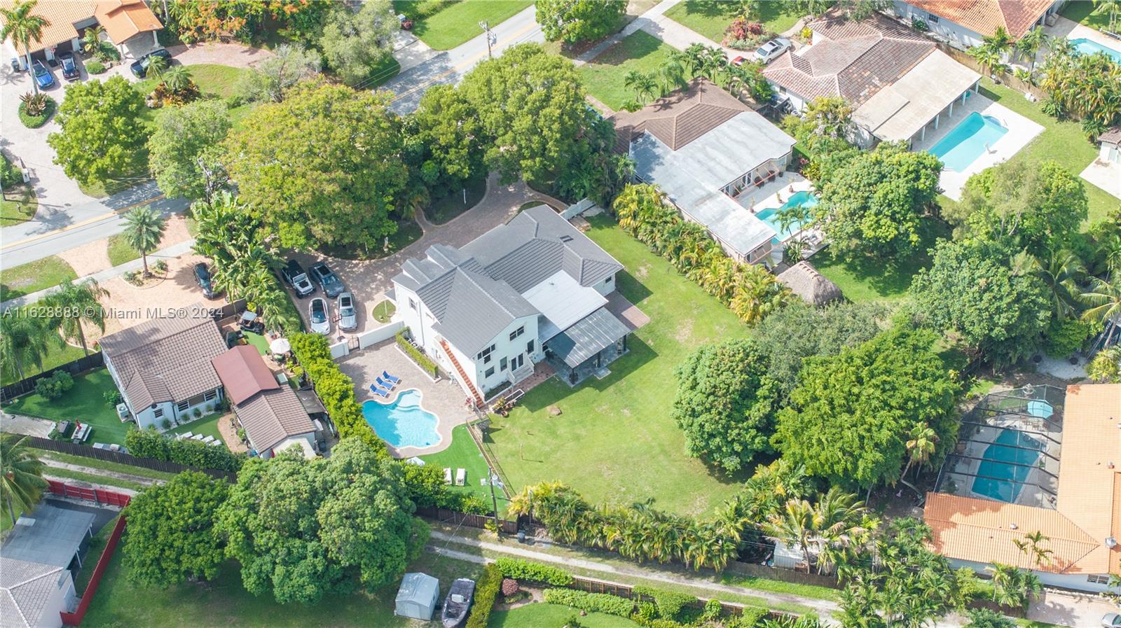 an aerial view of residential house with outdoor space and trees all around