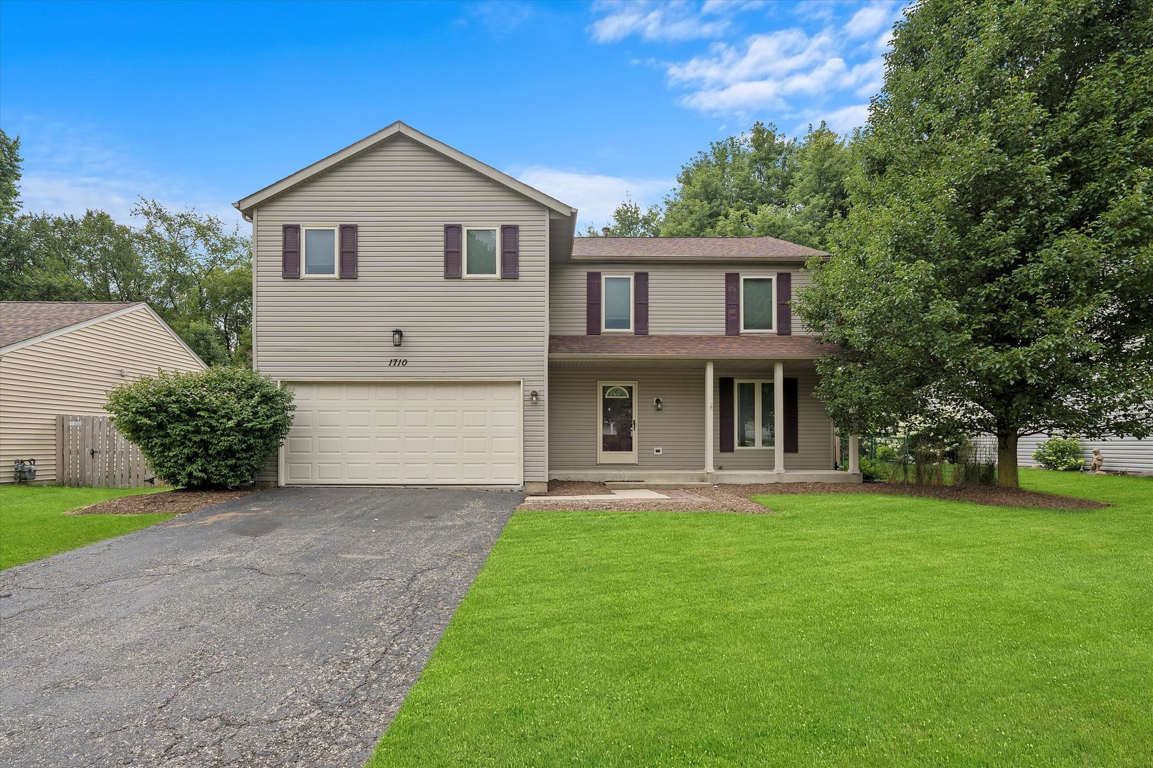 a front view of a house with a yard and trees