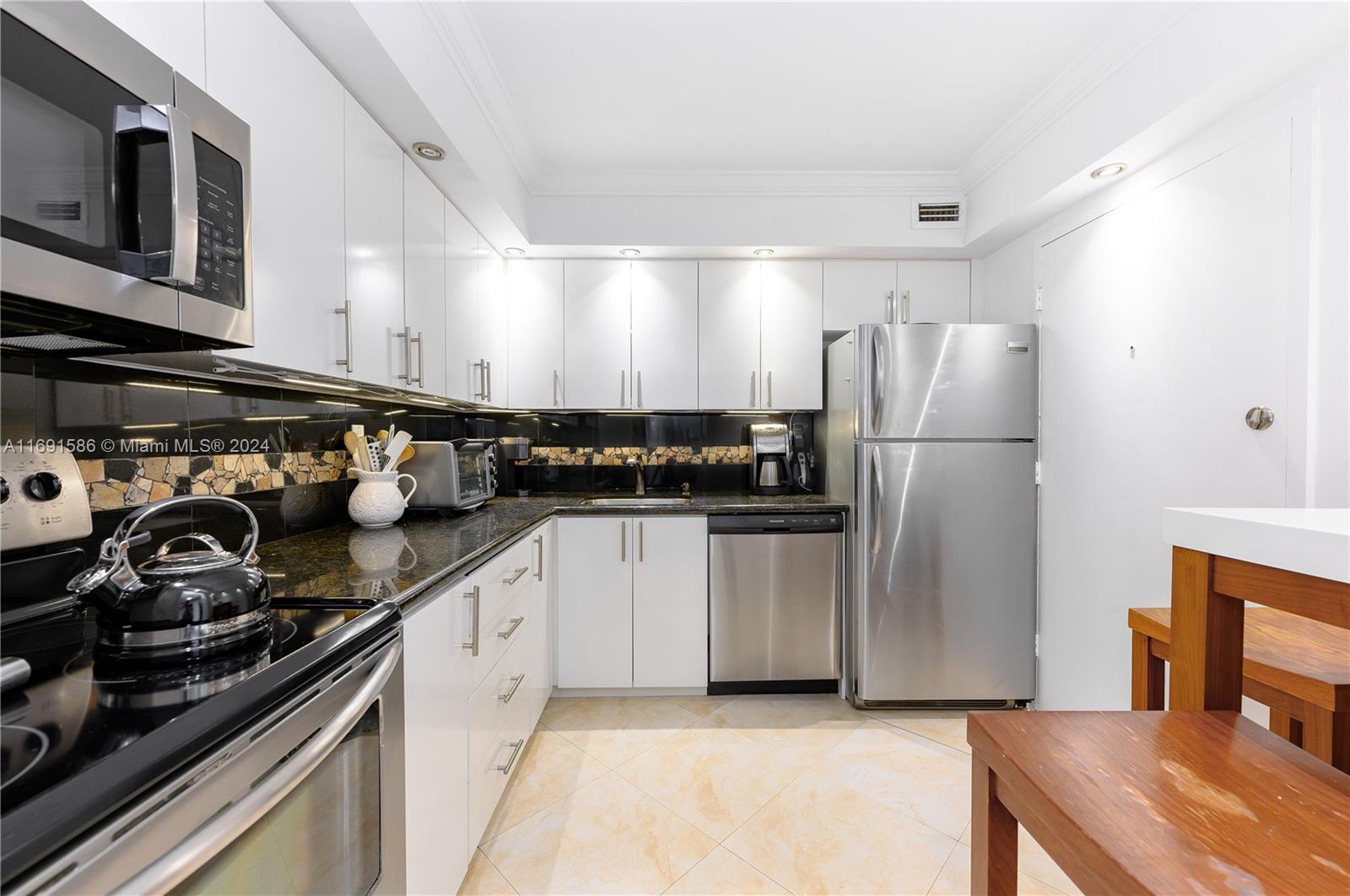 a kitchen with stainless steel appliances a refrigerator a sink and wooden cabinets