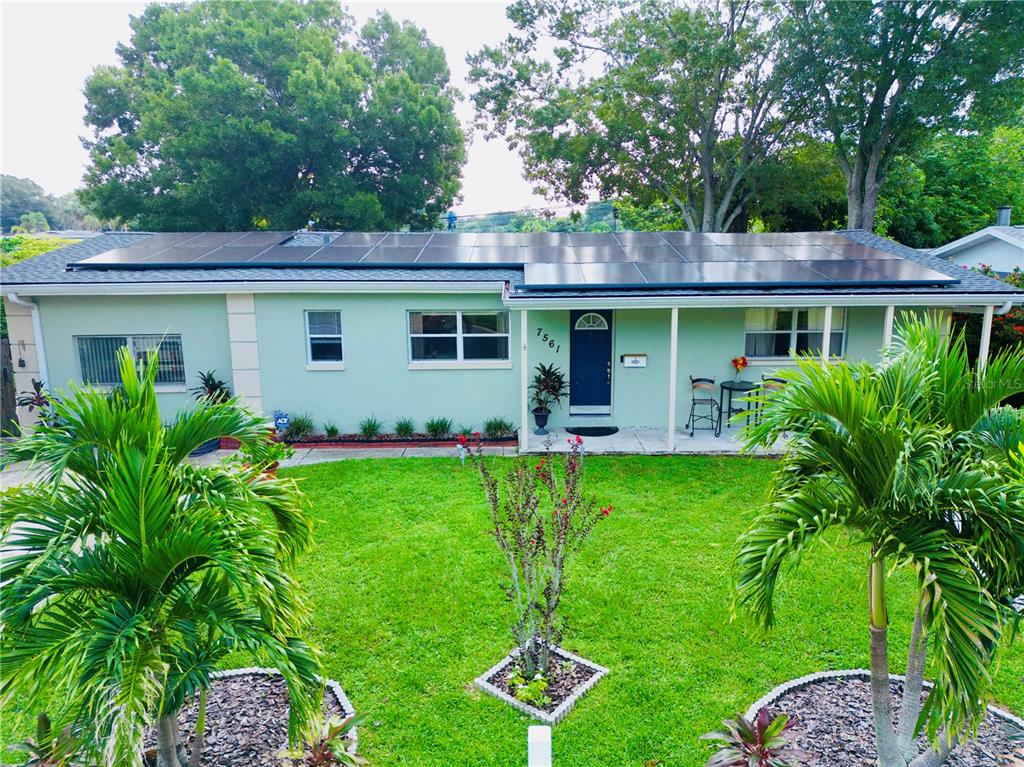 a view of a house with backyard and a garden