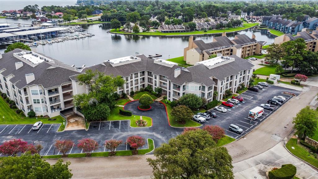 an aerial view of lake and residential houses with outdoor space and swimming pool