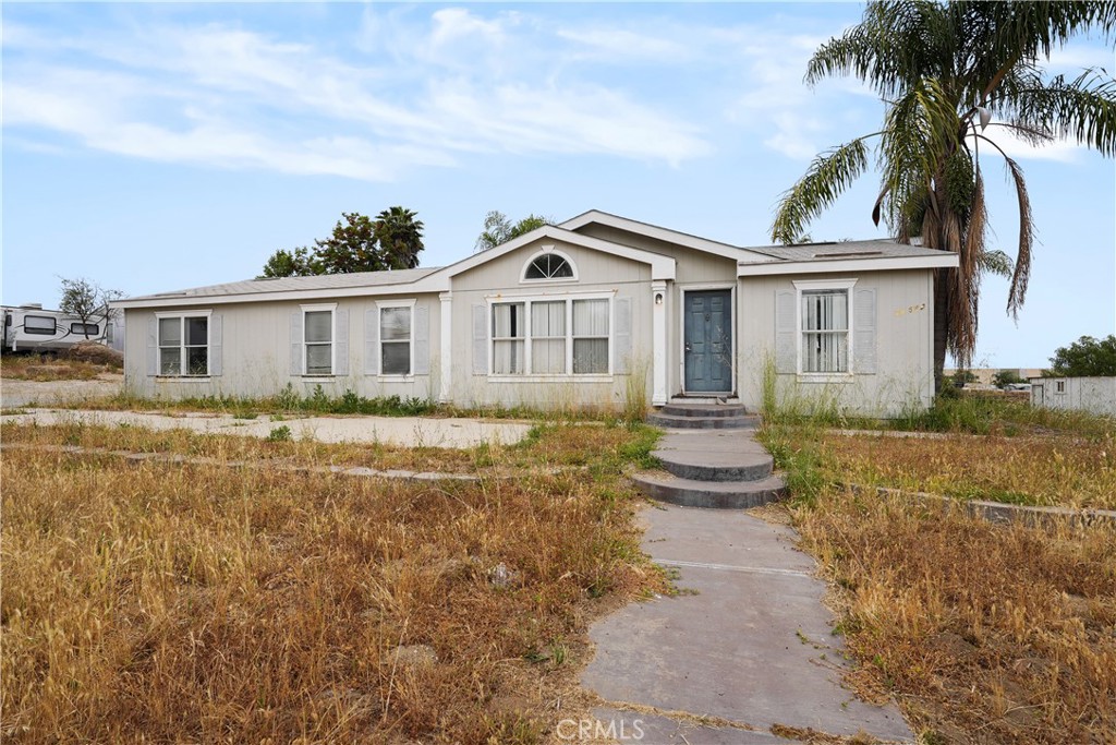 a front view of a house with a garden and yard