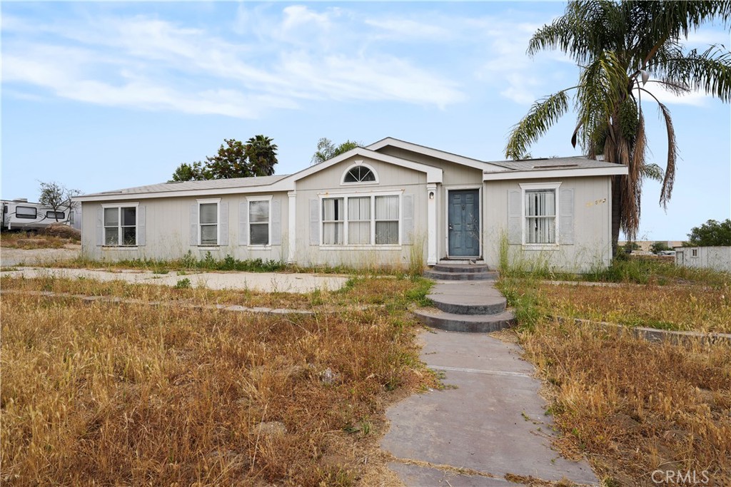 a front view of a house with a garden and yard