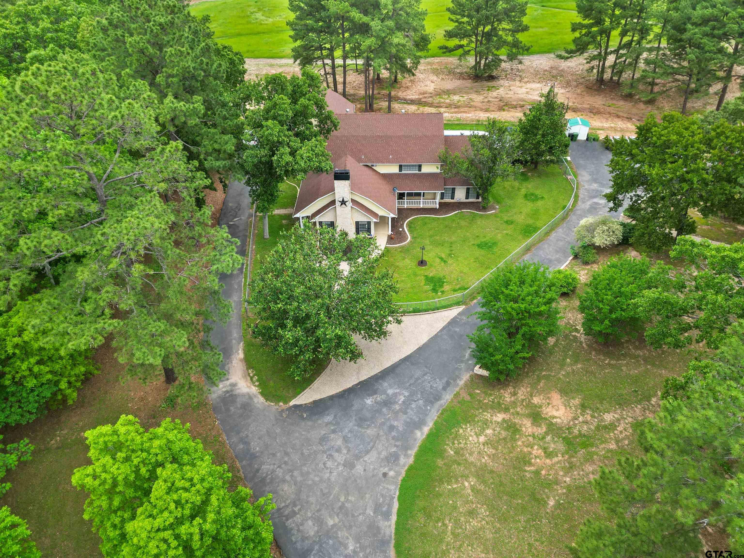 an aerial view of a house with a yard and lake view