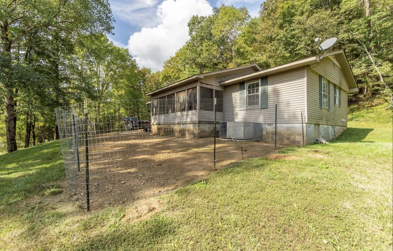 a view of a house with backyard and trees