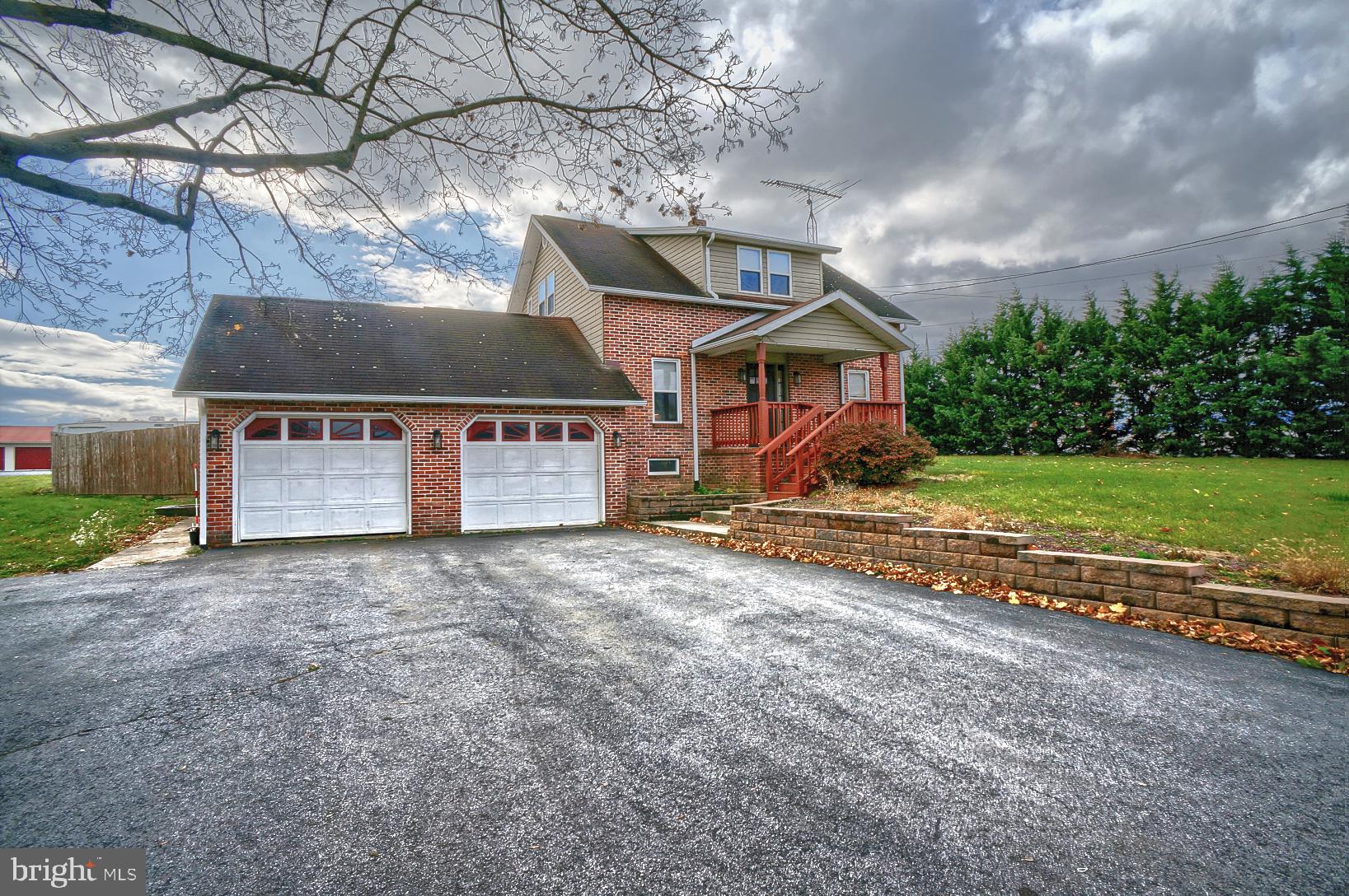 a view of a house with a yard and a large tree