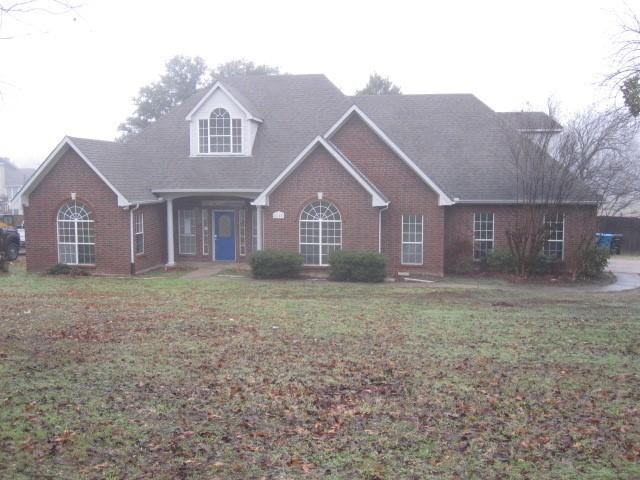 a view of a large house with a big yard and large tree