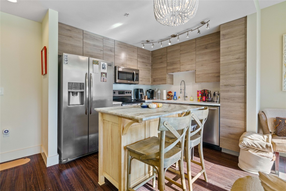 Kitchen on the 2nd floor with stainless steel appliances. Kitchen island stays