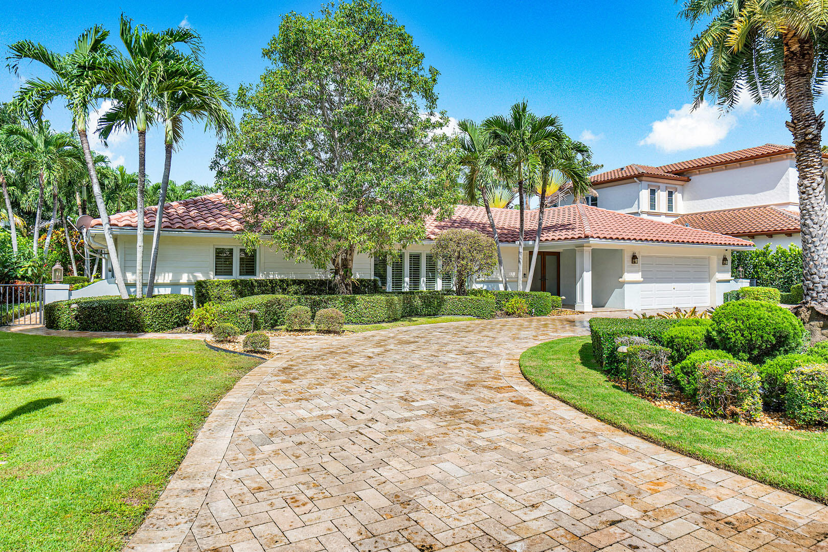 a front view of a house with a yard and potted plants